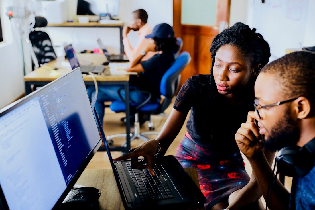 Dos jóvenes trabajando frente a un computador